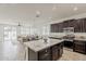 Open concept kitchen with island, dark cabinets, stainless appliances, and breakfast nook at 4067 S White Dr, Chandler, AZ 85249