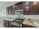 Kitchen with granite countertops, stainless steel appliances and dark wood cabinets at 4067 S White Dr, Chandler, AZ 85249