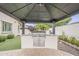 Outdoor kitchen with stainless steel grill, nestled in a gazebo overlooking the backyard at 4067 S White Dr, Chandler, AZ 85249