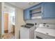 A laundry room featuring a washer and dryer, cabinets, and a view of the bathroom at 4114 E Muirwood Dr, Phoenix, AZ 85048