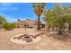 Backyard featuring a cozy fire pit, covered patio, and desert landscaping at 4922 W Fallen Leaf Ln, Glendale, AZ 85310