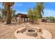 Backyard featuring a cozy fire pit, covered patio, and desert landscaping at 4922 W Fallen Leaf Ln, Glendale, AZ 85310