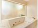 Bathroom with a jacuzzi tub and tile surround at 4922 W Fallen Leaf Ln, Glendale, AZ 85310
