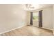 Bright bedroom features wood-look tile floors, ceiling fan, and window with patterned curtains at 4922 W Fallen Leaf Ln, Glendale, AZ 85310