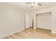 Bedroom with wood tile flooring, ceiling fan, and open closet at 4922 W Fallen Leaf Ln, Glendale, AZ 85310