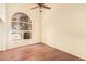 Bedroom with ceiling fan and a large arched window bringing in natural light at 4922 W Fallen Leaf Ln, Glendale, AZ 85310