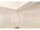 An empty walk-in closet with white walls, a wooden floor, and storage shelves on the walls at 4922 W Fallen Leaf Ln, Glendale, AZ 85310