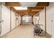 Spacious garage with white brick walls, exposed ceiling beams, and a roll-up door at 4922 W Fallen Leaf Ln, Glendale, AZ 85310