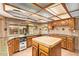 Well-lit kitchen with a central island, garden window, stainless steel appliances, and custom cabinets at 4922 W Fallen Leaf Ln, Glendale, AZ 85310