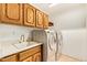Laundry room with sink, countertop, and front-loading washer and dryer at 4922 W Fallen Leaf Ln, Glendale, AZ 85310
