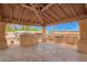 View of outdoor kitchen with built-in grill and countertop on a stone-paved covered patio at 4922 W Fallen Leaf Ln, Glendale, AZ 85310