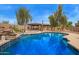The backyard pool is surrounded by lush landscaping and outdoor kitchen; perfect for relaxation at 4922 W Fallen Leaf Ln, Glendale, AZ 85310