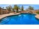 Backyard pool with rock waterfall features and lush landscaping at 4922 W Fallen Leaf Ln, Glendale, AZ 85310