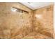 Shower with brown tiles and a small window at 4922 W Fallen Leaf Ln, Glendale, AZ 85310