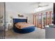 Stylish primary bedroom featuring a unique round bed, a ceiling fan, and sliding glass doors to the outside at 5231 E Tamblo Dr, Phoenix, AZ 85044
