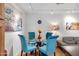 Cozy dining area with glass table and blue chairs, illuminated by modern track lighting at 5231 E Tamblo Dr, Phoenix, AZ 85044