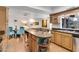 Bright kitchen with an island, tan cabinetry, tile floors, and open to the living area at 5231 E Tamblo Dr, Phoenix, AZ 85044