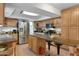Spacious kitchen features wood cabinetry, stainless steel appliances, and a long island with bar seating at 5231 E Tamblo Dr, Phoenix, AZ 85044