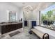 Beautiful bathroom featuring a glass walk-in shower, granite counters, modern chandelier, and soaking tub with outdoor views at 5404 N 41St St, Phoenix, AZ 85018