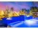 Detail of the pool's spa illuminated with blue lighting and water features enhanced by lush landscaping at 5404 N 41St St, Phoenix, AZ 85018