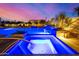 Pool and spa with lights, waterfalls, and lush landscaping at dusk at 5404 N 41St St, Phoenix, AZ 85018