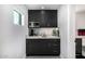 Convenient wet bar with dark cabinetry, marble countertop, microwave, and sink for easy entertaining at 5404 N 41St St, Phoenix, AZ 85018