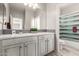 Bathroom featuring double vanity, modern mirror, and enclosed bathtub with shower at 5407 S Tatum Ln, Gilbert, AZ 85298