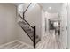 Hallway with staircase, gray tone, wood-look tile flooring, and white walls leading into an open-concept living space at 5407 S Tatum Ln, Gilbert, AZ 85298