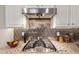 Gourmet kitchen features a gas stove with stunning backsplash and granite countertops at 5407 S Tatum Ln, Gilbert, AZ 85298