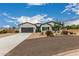 Charming single-story home featuring desert landscaping, gray stucco, and a spacious driveway at 5670 E Singletree St, Apache Junction, AZ 85119