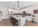 Bright kitchen boasts white cabinetry, a center island with seating, and stainless steel appliances at 5670 E Singletree St, Apache Junction, AZ 85119