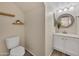 This half-bath offers a floating wood shelves and updated vanity with round mirror at 5808 E Brown Rd # 49, Mesa, AZ 85205