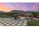 Backyard patio with modern firepit, artificial turf, and pavers overlooking distant mountains at 6102 E Sage Dr, Paradise Valley, AZ 85253