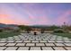 Inviting backyard with a modern fire pit, elegant stone patio, and mountain views at sunset at 6102 E Sage Dr, Paradise Valley, AZ 85253