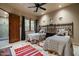 Neutral-toned bedroom with two twin beds, rustic furniture, stylish lighting, and a small window with a forest view at 6102 E Sage Dr, Paradise Valley, AZ 85253