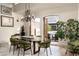 Elegant dining room with travertine floors, statement chandelier, and French doors leading to outdoor patio at 6102 E Sage Dr, Paradise Valley, AZ 85253