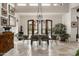 Elegant dining room with travertine floors, statement chandelier, and French doors leading to the outdoor space at 6102 E Sage Dr, Paradise Valley, AZ 85253
