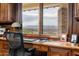 Comfortable home office featuring wood cabinets, a large window with a mountain view, and a well-lit workspace at 6102 E Sage Dr, Paradise Valley, AZ 85253