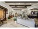 Expansive living room featuring travertine floors, beamed ceilings, and seamless flow to dining and kitchen areas at 6102 E Sage Dr, Paradise Valley, AZ 85253