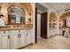 Elegant bathroom with arched entryways, dual vanities, stone accents, and beautiful tile flooring at 6102 E Sage Dr, Paradise Valley, AZ 85253