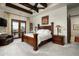 Spacious bedroom with wooden ceiling beams, a large ornate bed, and a sliding glass door leading to an outdoor patio at 6102 E Sage Dr, Paradise Valley, AZ 85253