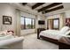 Bright main bedroom featuring wooden ceiling beams, large windows and doors to a patio, and a relaxing sitting area at 6102 E Sage Dr, Paradise Valley, AZ 85253