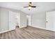 Spacious bedroom with wood-look flooring, ceiling fan, and ensuite bathroom entrance at 6921 W Wanda Lynn Ln, Peoria, AZ 85382