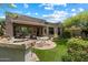 Expansive backyard featuring stone grill, covered patio, and well-maintained lawn at 7291 E Eagle Feather Rd, Scottsdale, AZ 85266