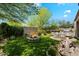 Landscaped backyard featuring a fire pit, manicured lawn, and patio with BBQ and outdoor seating at 7291 E Eagle Feather Rd, Scottsdale, AZ 85266
