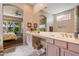 Bathroom with double sinks, large mirror and view to bedroom with ceiling fan at 7291 E Eagle Feather Rd, Scottsdale, AZ 85266