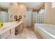 Bright bathroom featuring a double sink vanity, glass block shower and soaking tub at 7291 E Eagle Feather Rd, Scottsdale, AZ 85266
