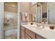 Bathroom showcasing a shower and tub combination behind a glass door and neutral tile at 7291 E Eagle Feather Rd, Scottsdale, AZ 85266