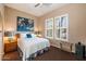 Bedroom with white shuttered windows, bed with blue accent pillow and dark brown carpet at 7291 E Eagle Feather Rd, Scottsdale, AZ 85266