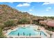 Aerial view of a community pool surrounded by lounge chairs and desert landscaping at 7291 E Eagle Feather Rd, Scottsdale, AZ 85266